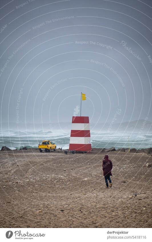 Man runs toward rescue tower in bad weather on beach Structures and shapes Nature reserve Subdued colour Copy Space left Copy Space right Copy Space top