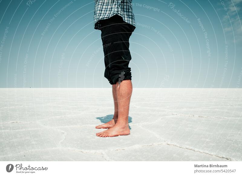 Man standing barefoot on the Salt Flats in Bonneville, Utah copy space feet male legs bonneville salt flats utah landscape lake travel person outdoors