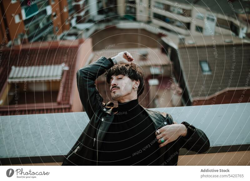 Cool man in jacket on rooftop with closed eyes cool brunet urban leather industrial male hipster mustache casual confident successful lean turtleneck street