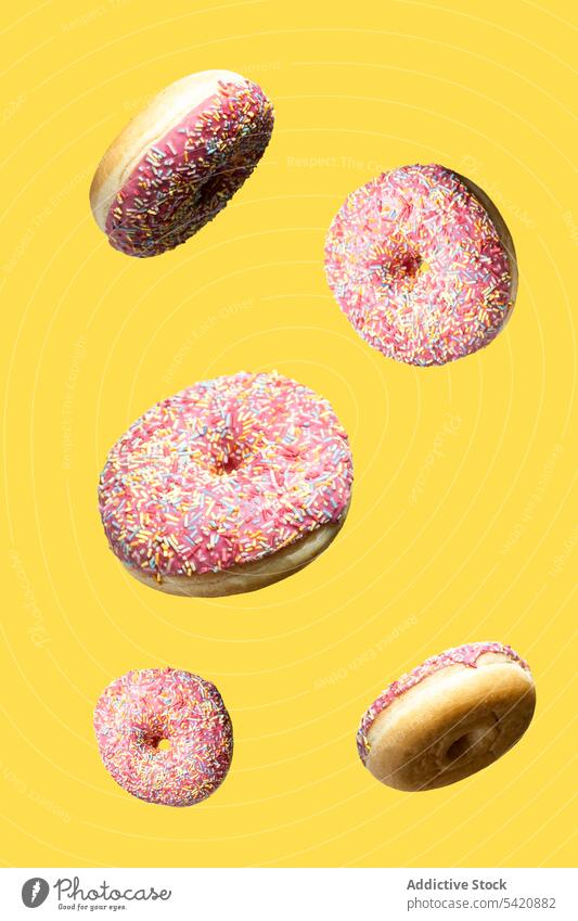 Pattern from fresh pink donuts dessert sweet floating food pastry colorful treat doughnut set collection calorie delicious tasty yummy sugar glazed icing
