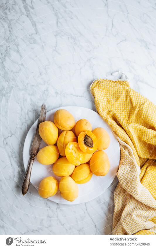 Plate with fresh apricots on white marble table fruit ripe plate yellow orange natural food delicious tasty healthy organic ingredient nutrition meal cuisine