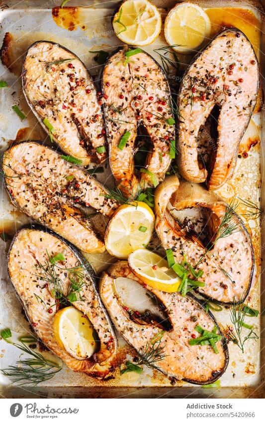 Appetizing fish steaks with lemon and herbs salmon roast tray seasoning healthy seafood spice slice tasty natural meal citrus dish cuisine nutrition cut lunch