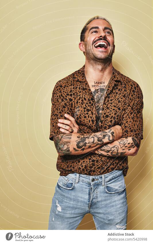Trendy ethnic guy in stylish outfit standing in studio man trendy style cheerful fashion leopard model jeans male cloth modern cool confident handsome smile