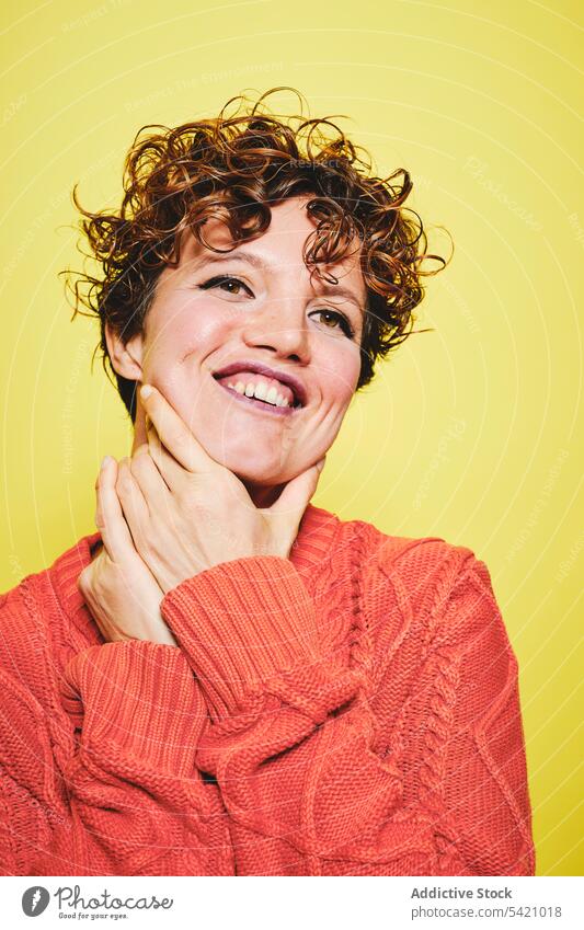 Excited woman in warm sweater in studio cheerful happy surprise excited style laugh trendy amazed knitted curly hair joy casual expressive vibrant vivid color