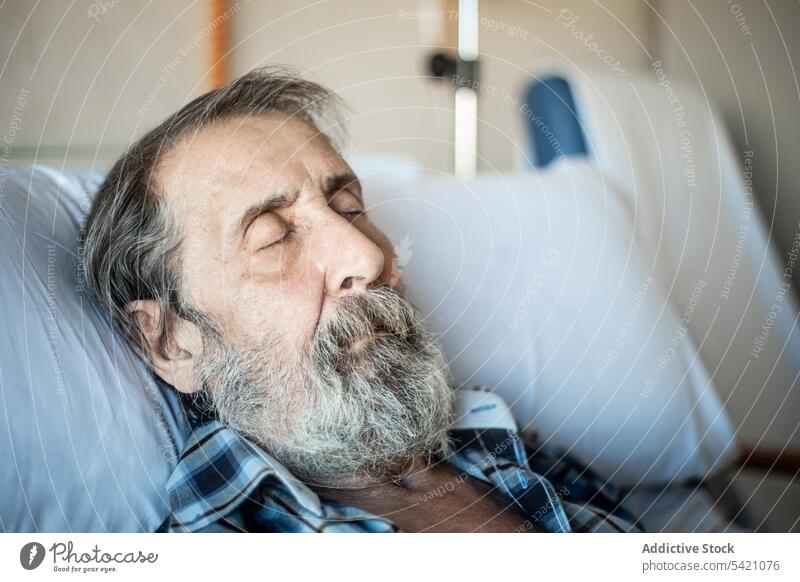 Senior man sleeping in hospital bed senior ward elderly patient medicine illness tired clinic old blanket recovery disease control age unwell problem