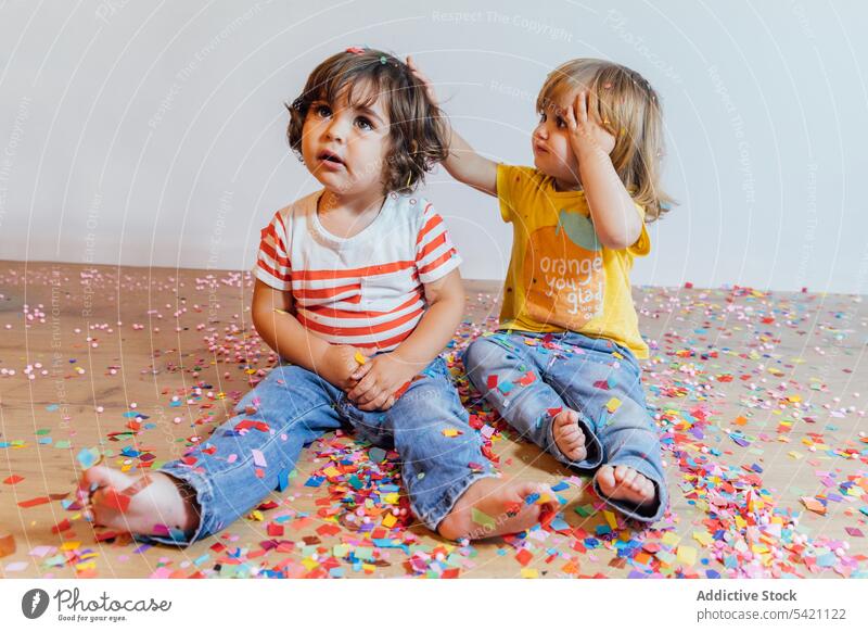 Cute toddlers having fun with confetti kid floor parquet together play happy sprinkle colorful little small child childhood children adorable playful cute