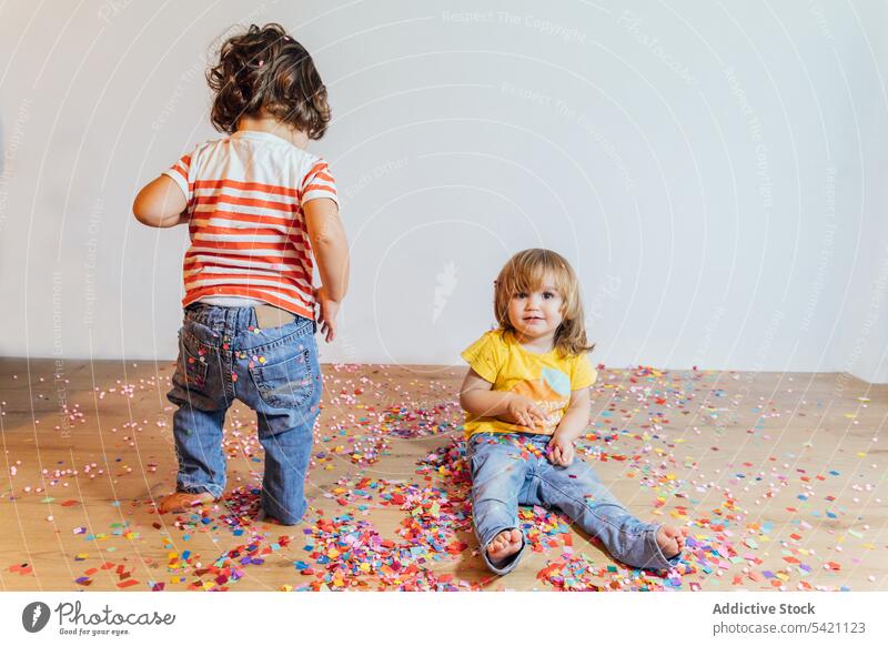 Cute toddlers having fun with confetti kid floor parquet together play happy sprinkle colorful little small child childhood children adorable playful cute
