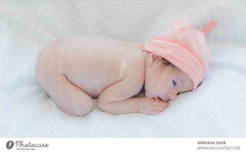 Cute baby in blanket and hat lying on bed newborn adorable child wrap portrait tiny pink sweet little infant childhood childcare healthy cute rest babyhood warm