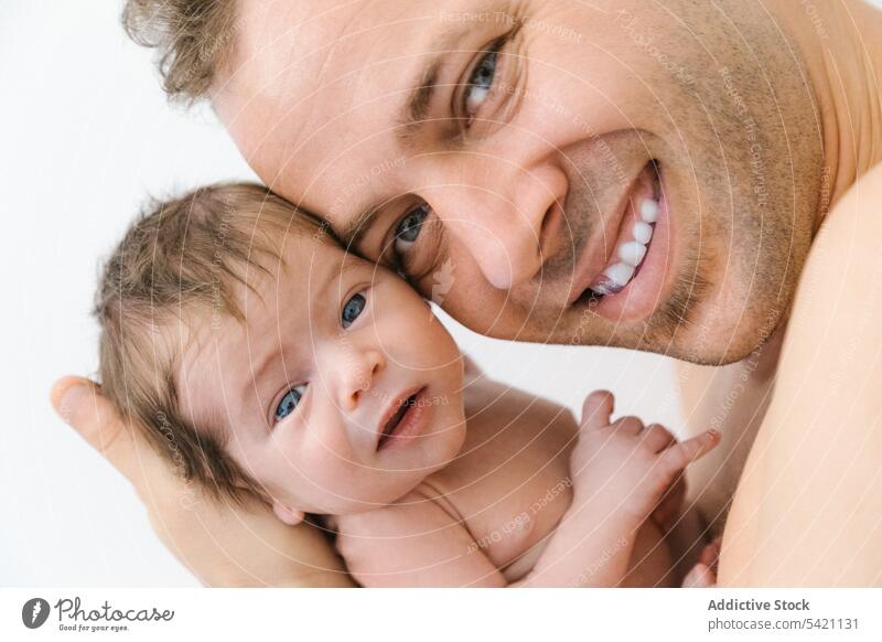 Happy father with little baby newborn happy man love parent embrace cuddle portrait cheerful male child hug smile kid dad together sweet infant childhood care