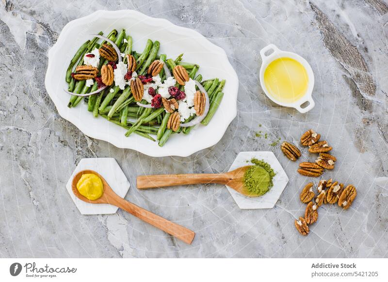 Salad with green beans and nuts on marble table salad vegetarian pecan vegetable goat cheese seasoning dressing ingredient mix plate olive oil mustard matcha