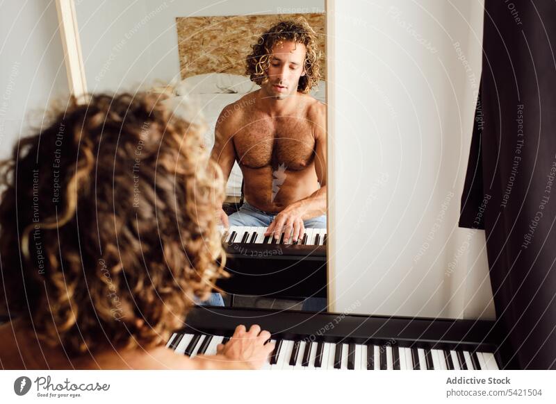 Shirtless man playing piano at home rehearsal musician melody instrument practice pianist male skill sound keyboard player entertain artist perform compose song