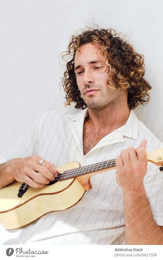 Tranquil man playing ukulele on white background music musician song serene tranquil handsome player male instrument relax peaceful harmony sound melody