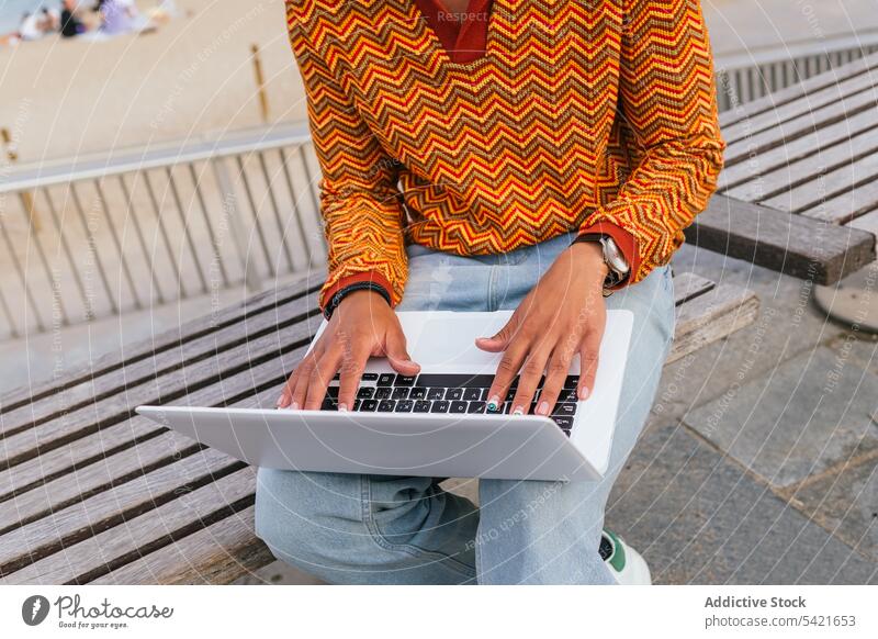 Anonymous young man using laptop on beach happy student freelance style sea typing positive ethnic trendy smile afro curly hair male modern cheerful work remote