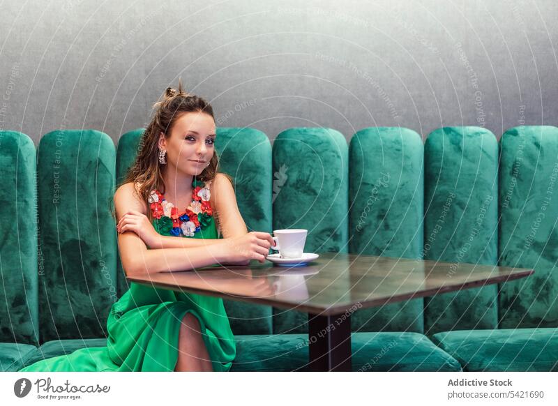 Young woman in fashionable green dress resting in cafe style color elegant coffee bright female model young teen teenage floral earring charming colorful beauty