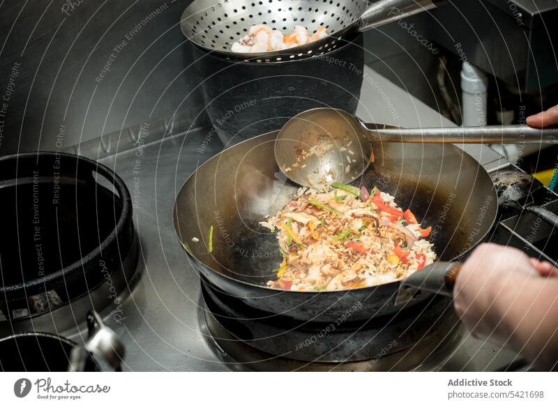 Crop chef cooking shrimp fried rice in wok in kitchen fry prawn vegetable asian food culinary restaurant prepare meal seafood cuisine dish pan process recipe