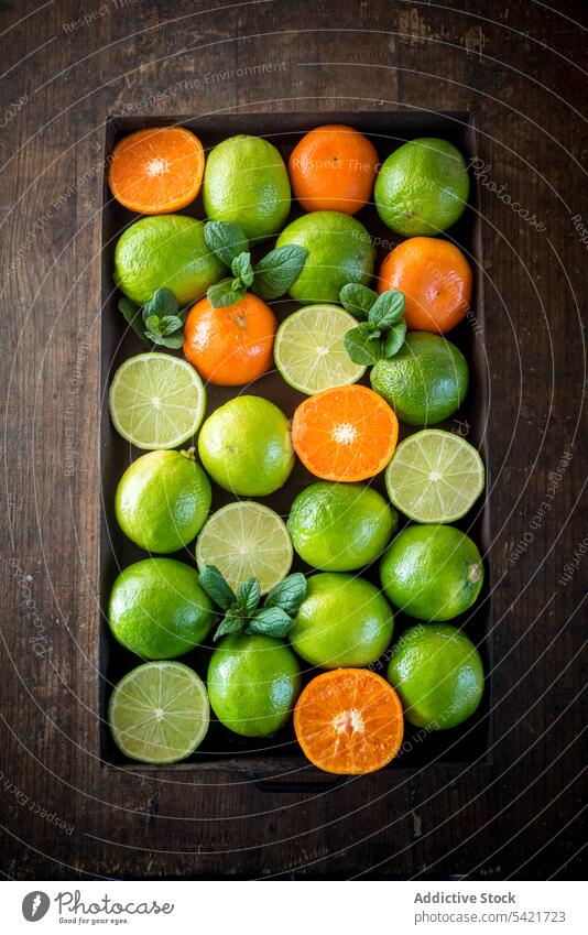 Limes and oranges in container on wooden table lime box harvest citrus healthy food ripe fresh raw sour fruit organic rustic vitamin green vegetarian natural