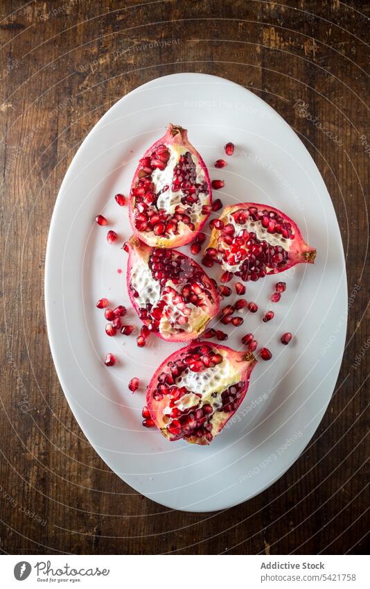 Cut ripe pomegranate on plate fruit food natural red seed cut fresh vitamin piece tropical organic healthy raw bright color juice edible product gastronomy