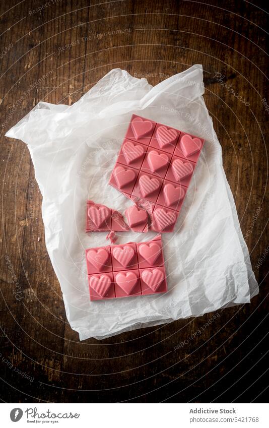Pink chocolate bar with hearts pink food sweet desert shape color piece dessert symbol design love romantic tasty valentine yummy treat wooden handmade table