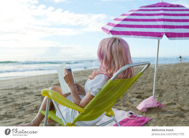 Unrecognizable woman with tablet in deckchair on beach work freelance vacation summer using seashore female lounger gadget device sit browsing sand remote job