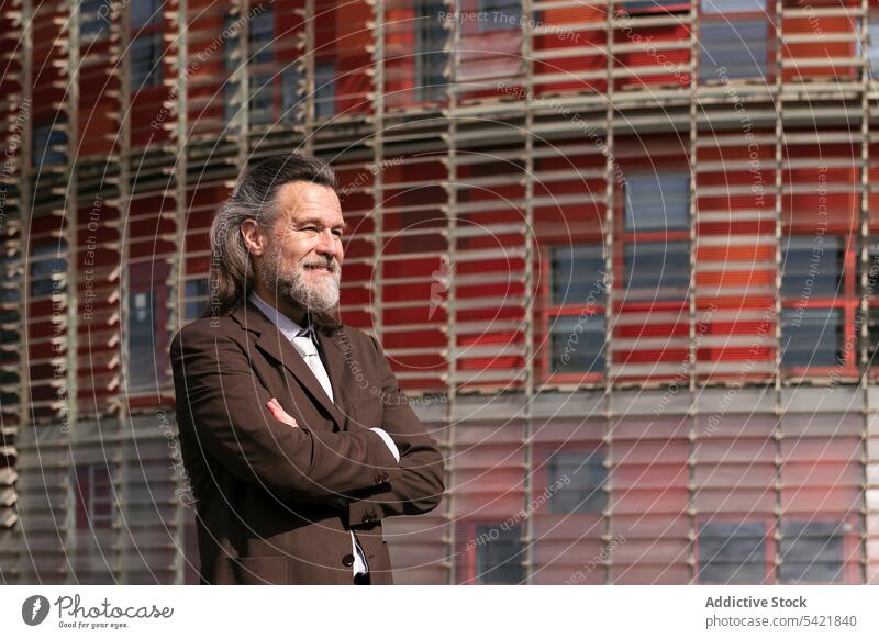 Confident mature bearded businessman standing near building confident style pensive urban suit positive success dream middle age aged gray hair modern lifestyle