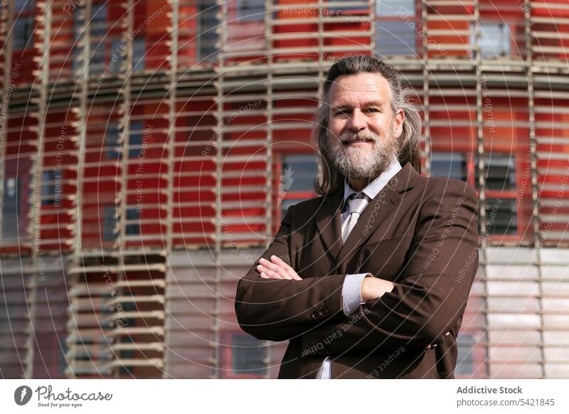 Confident mature bearded businessman standing near building confident style pensive urban suit positive success dream middle age aged gray hair modern lifestyle
