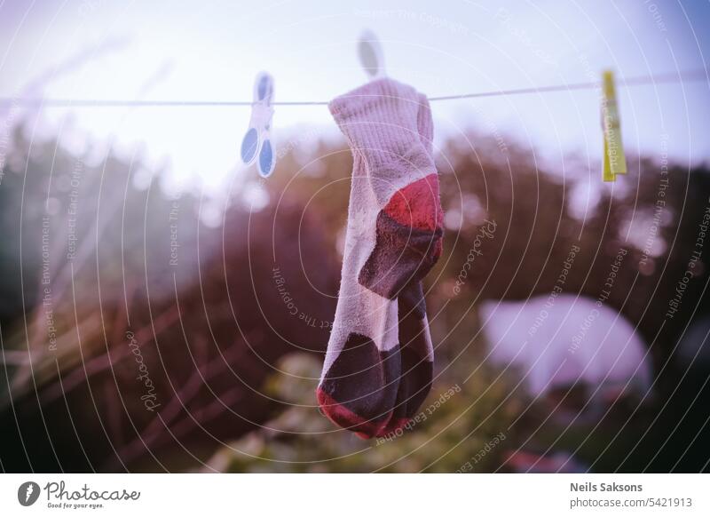 A pair of socks drying on a clothesline in the garden. fresh textile black cotton fashion hanging clothes silhouette hanging socks child and adult string style