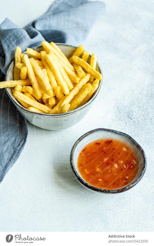 French fries and sour sweet sauce french bowl ceramic white surface napkin blue cloth blur high angle from above food dinner meal prepared dish cuisine recipe