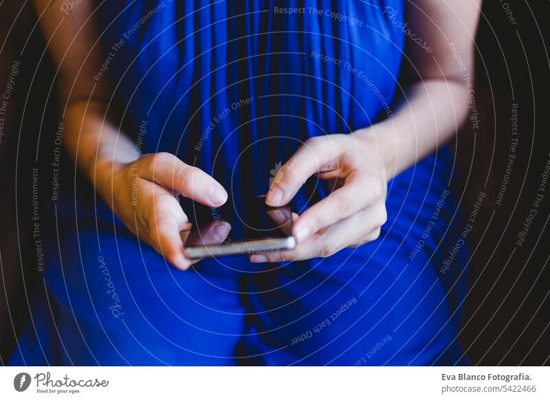 top view of a young woman using mobile phone. wearing a casual blue dress. Indoors, technology and lifestyle hipster stylish concept smart nails summer overhead