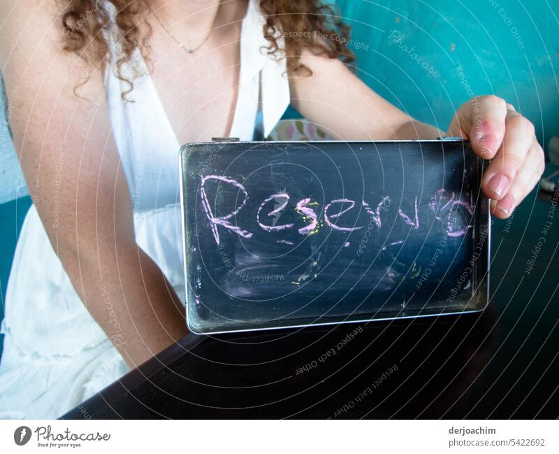 A pretty lady holds the small sign in her hand : Reserved reserve Resolve Day portrait Contentment Exterior shot Human being Colour photo Elegant Esthetic