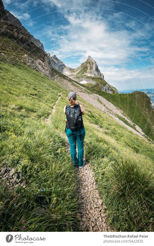 Woman hiking in front of mountain and slope Vantage point Panorama (View) Mountain Sky Clouds Alpstein hiking country appenzellerland Appenzell Grass stones