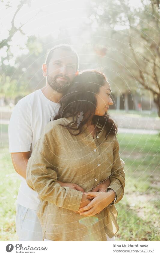 couple hugging in summer park in olive grove in green olive color palette. Earthy tones love and couple goals aesthetic. family together Olive grove linen