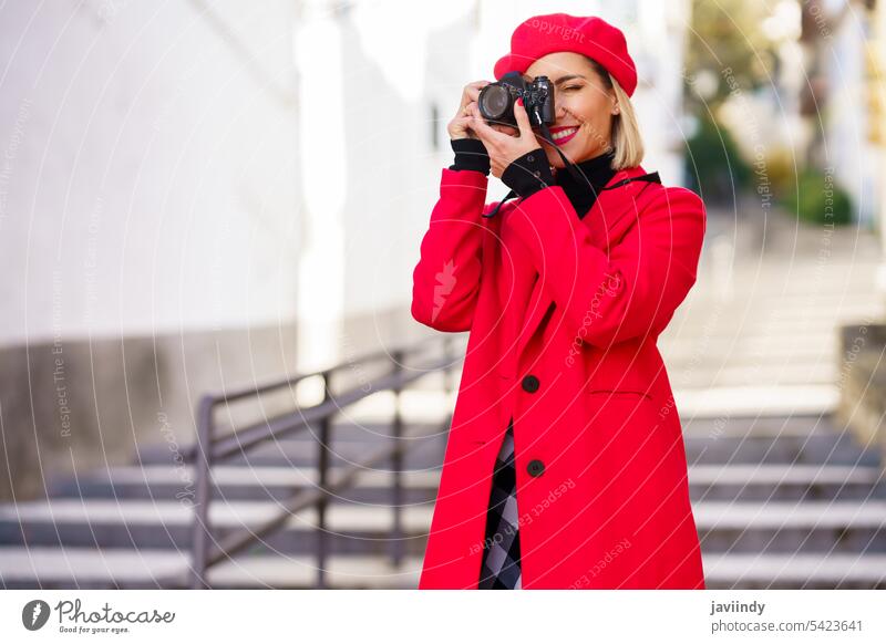 Elegant woman taking picture on street with red clothes. photo camera photographer take photo photography hobby building style fashion design feminine apparel