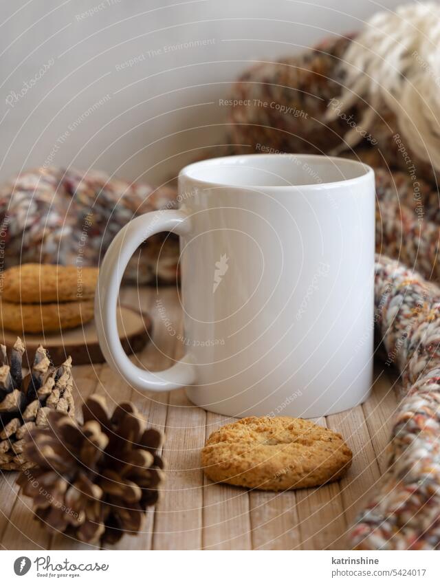 White coffee mug on wooden table near pine cones, cookies and sweater, winter mockup blank white mock up christmas brown december Close up cosy copy space boho