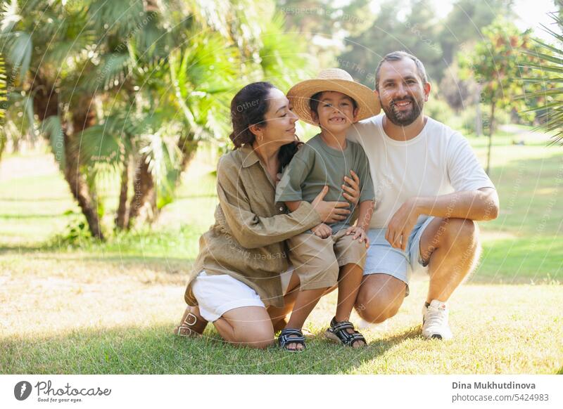 happy family smiling with a son in park outdoors in summer mom dad father mother parenthood parents fatherhood motherhood love together child childhood bonding