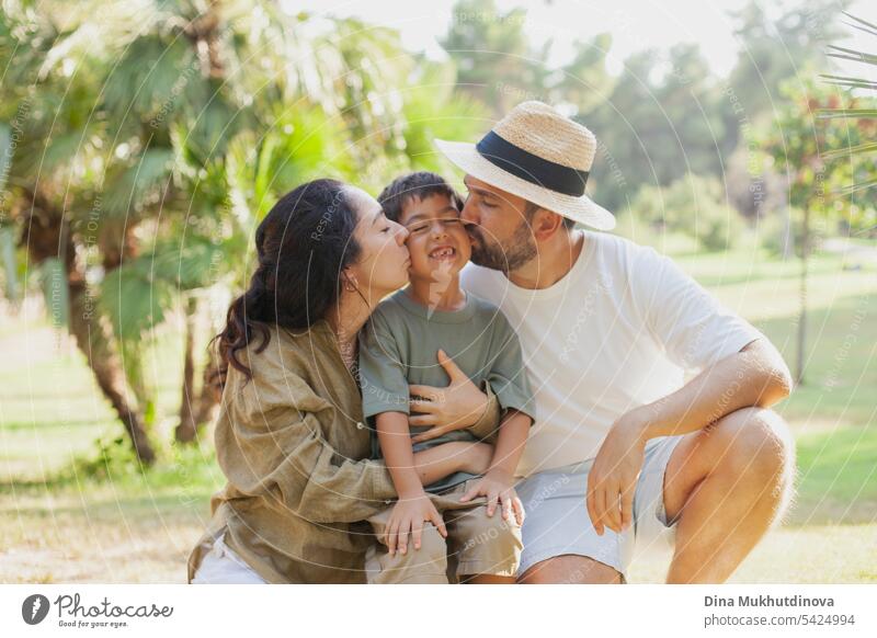 happy family smiling with a son in park outdoors in summer mom dad father mother parenthood parents fatherhood motherhood love together child childhood bonding