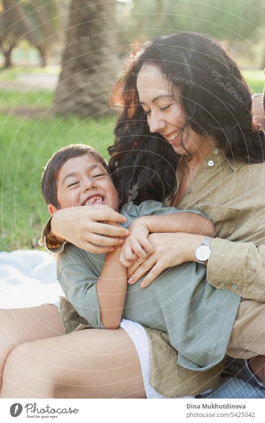 mother and son laughing  in the green park in summer on vacation. Happy family. Mother's Day. Motherhood concept. Boy (child) boy kid childhood mother and child