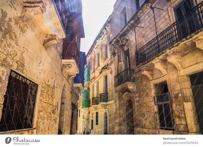 Traditional Maltese limestone buildings with coloured balconies in the vibrant alleys of the old city Birgu, Citta Vittoriosa without crowd.