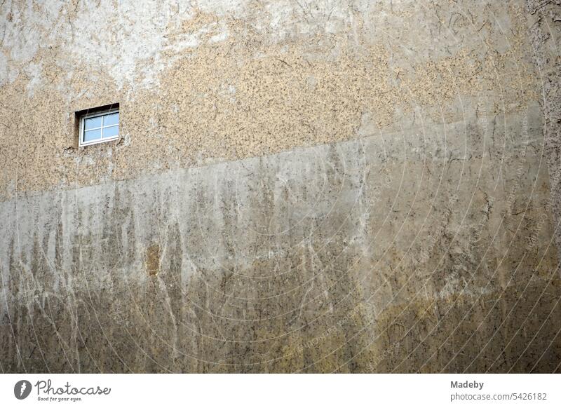 Lone muntin window in a washed out facade in beige and natural colors in a backyard on Braubachstraße in downtown Frankfurt am Main in Hesse, Germany Window