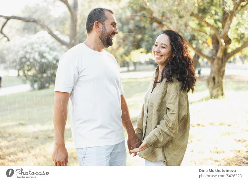 couple smiling in summer park in olive grove in green olive color palette. Earthy tones love and couple goals aesthetic. hug family together Olive grove linen