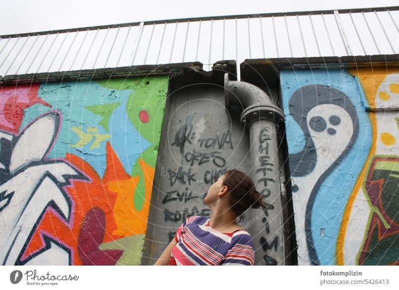 young woman looking at graffiti wall Graffiti Wall (building) Wall (barrier) Woman Young woman Youth (Young adults) Human being Graffiti wall variegated Facade