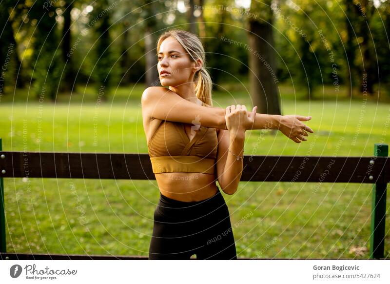 Pretty young woman stretching in the park fit fitness female person exercise training summer nature health lifestyle outdoors workout beauty spring beautiful