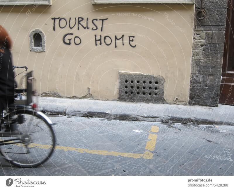 Writing "Tourist go home" on a house wall in Italy and rear wheel of a bicycle. Photo: Alexander Hauk tourist Wall (building) Criticism protest Gentrification