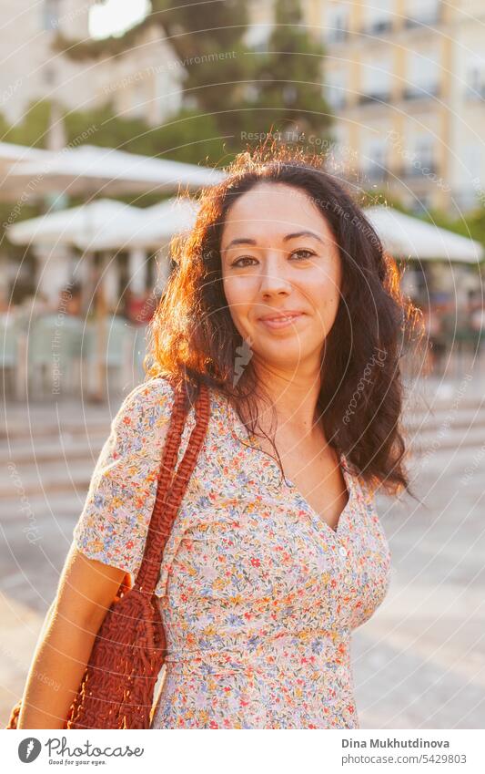 Beautiful female tourist at sunset in Valencia, Spain. Brunette woman summer dress with trendy crochet bag walking the street. beautiful gorgeous Tourism