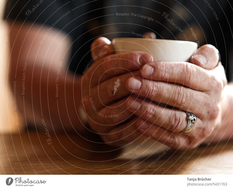 Man hands warm themselves on coffee cup Male Hands Coffee cup Cup Hot drink warm sb./sth. Warm up Coffee break cup in the hands Cozy To have a coffee Beverage
