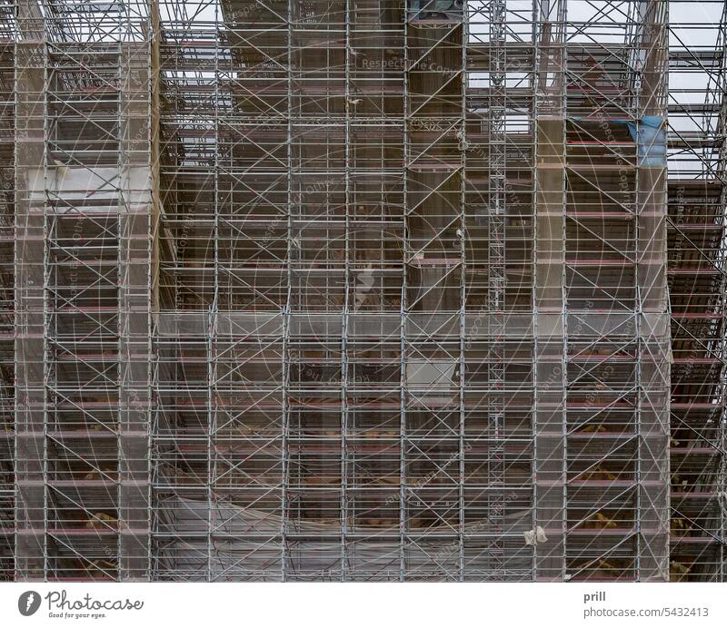Extensive scaffolding staging structure building support tube and coupler construction working platform frontal huge netting safety industrial extensive