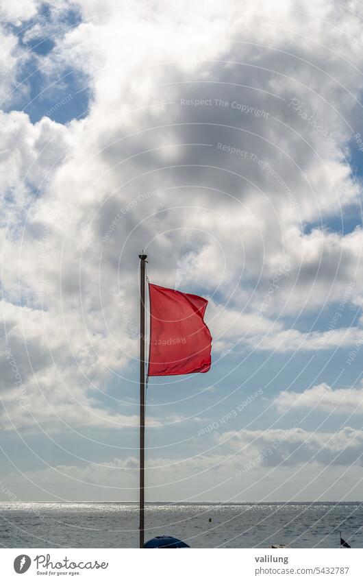 Red flag on the beach background banner caution coast danger dangerous forbidden holiday no prohibition protection red restrict safety sea shore sign sky stop