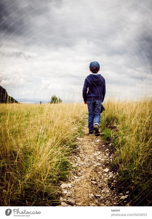 Child walking on narrow path towards horizon Horizon Follow the path hike Sky Hiking Lanes & trails To go for a walk Loneliness Calm Footpath Landscape Nature