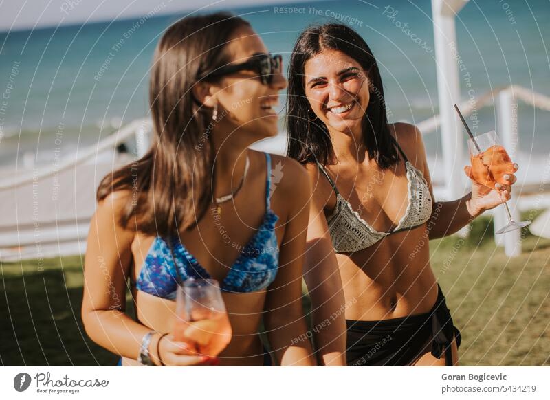 Smiling young women in bikini enjoying vacation on the beach adult clothing day drink drinking emotion fashion female happiness holiday italy leisure activity