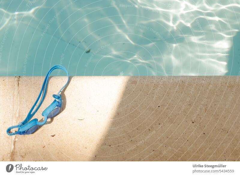 A blue diving goggles lies on the edge of the pool Summer vacation Sun Italy be afloat Dive Light Shadow Evening sun Water Sun reflected in water relaxation
