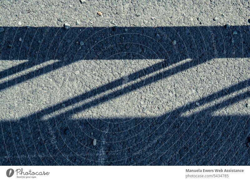 Vertical view of the ground on the shadow of a railing Shadow shadow cast Street Transport Railroad crossing Control barrier Border Contrast Rich in contrast